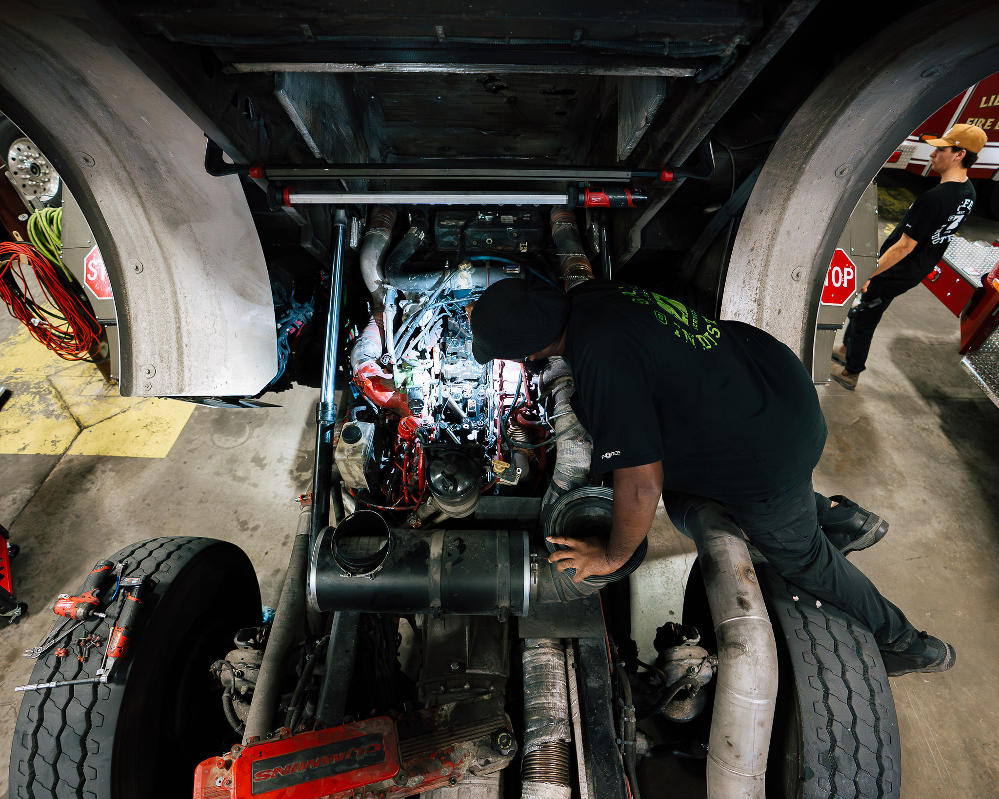 A Safe Industries technician working deep in a fire truck engine bay